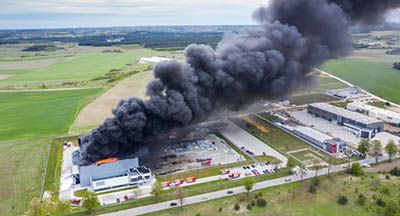 usine en feu avec un grand panache de fumée noire symbolisant les risques des ICPE